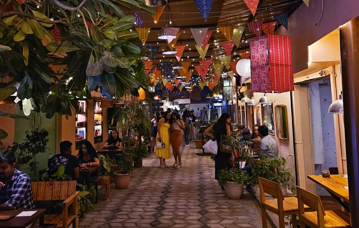 Cozy alleyway with fairy lights colorful bunting flags and outdoor cafes in Champa Gali Saket