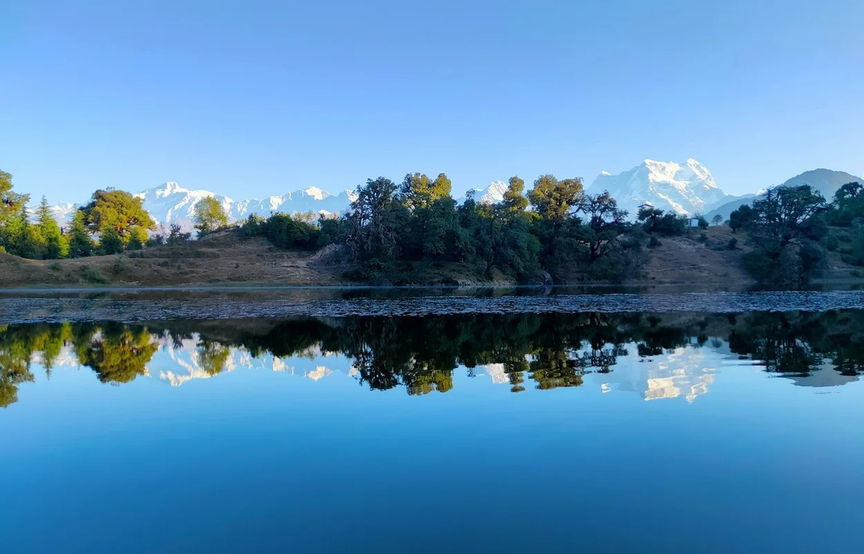 Deoriatal lake reflecting the Chaukhamba mountain peak on a clear morning near Chopta