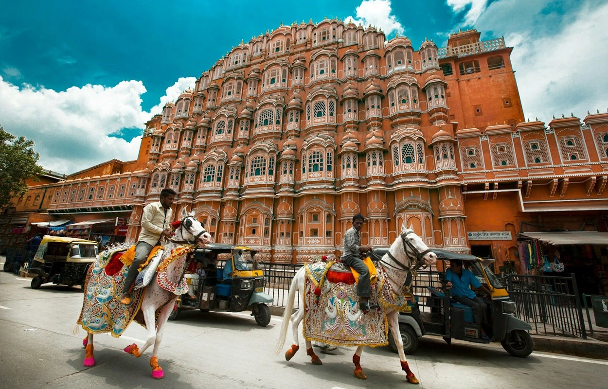 Iconic pink sandstone facade of Hawa Mahal Jaipur with small jharokha windows