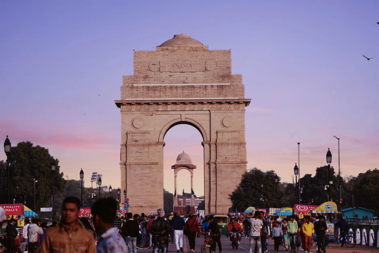 Illuminated sandstone archway of the India Gate war memorial during twilight in Delhi