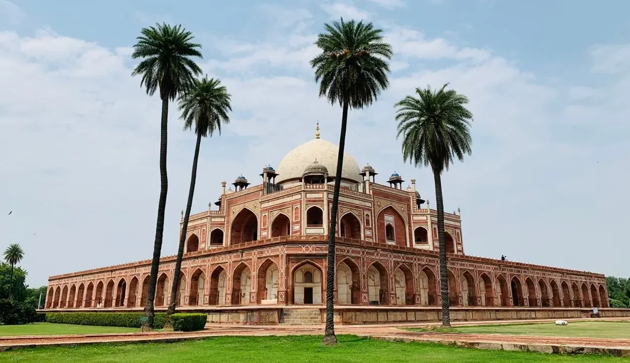 Red sandstone facade and white dome of Humayun's Tomb surrounded by Mughal charbagh gardens in Delhi