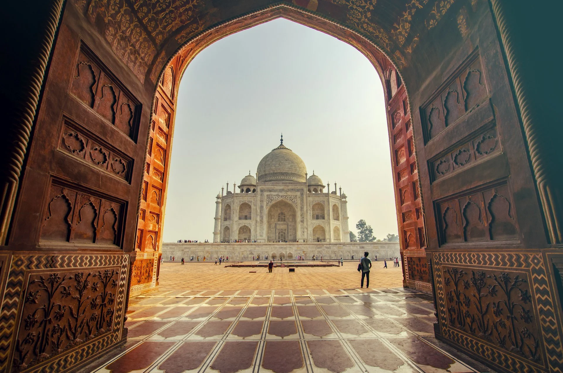 The iconic Taj Mahal surrounded by lush gardens at golden hour