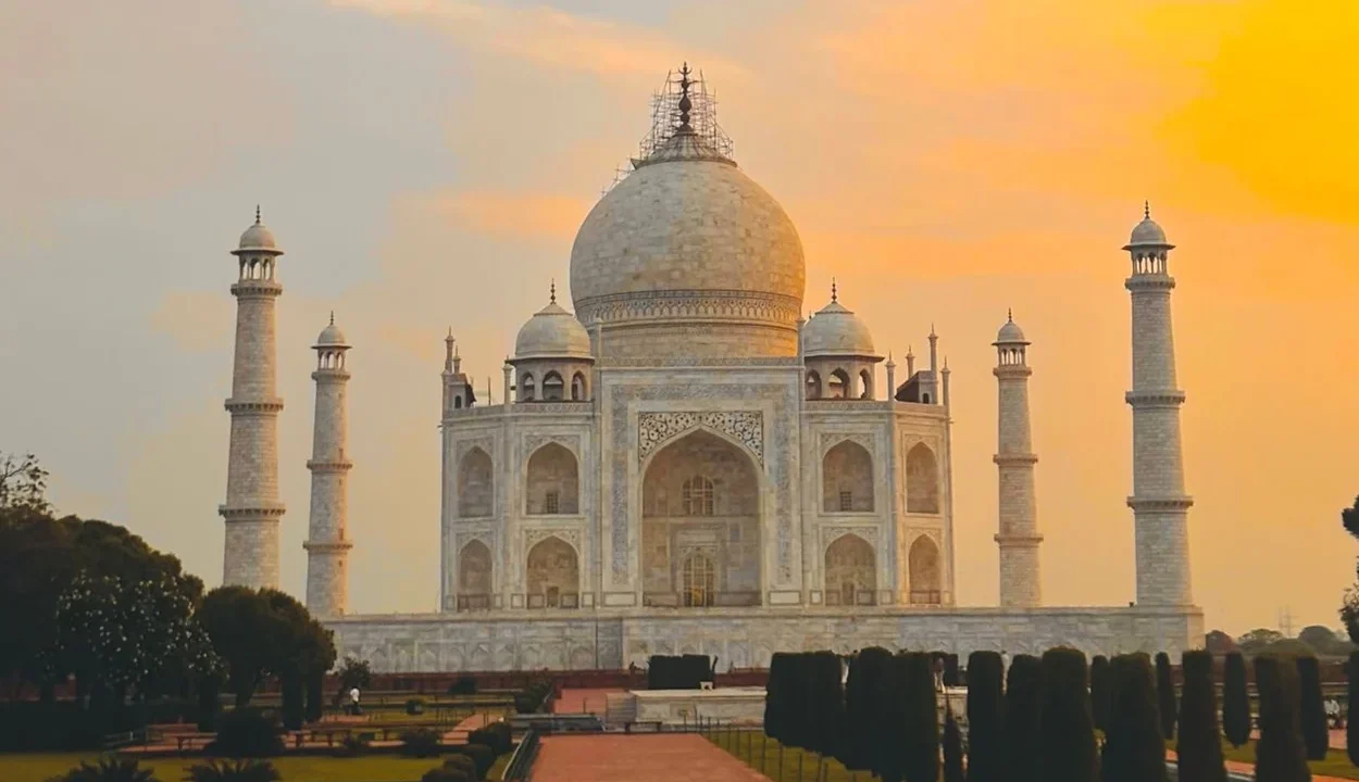 Taj Mahal surrounded by gardens during a golden sunset in Agra