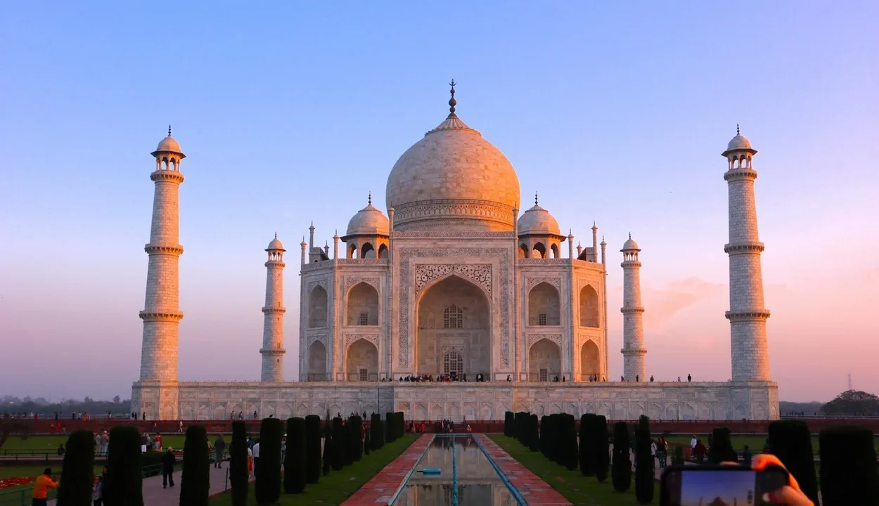 Tourist taking a photo of the Taj Mahal during sunrise in Agra