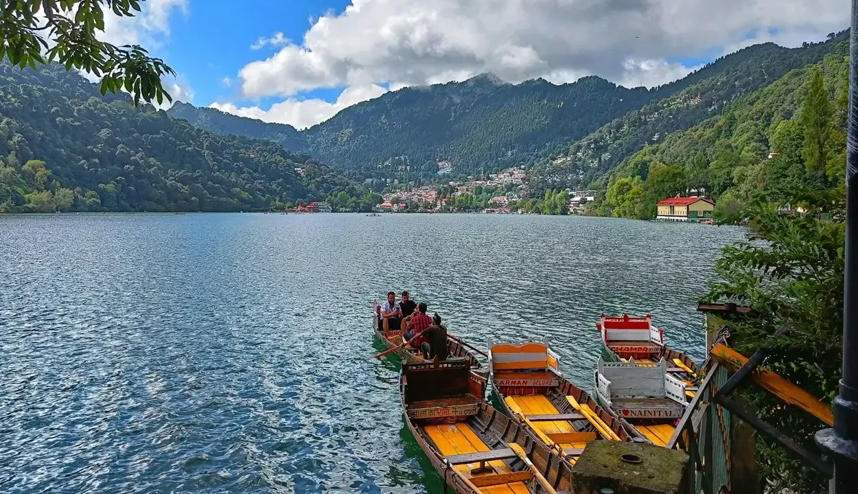 Picturesque view of traditional wooden boats on Naini Lake showing how to reach Nainital from Delhi for a weekend trip.