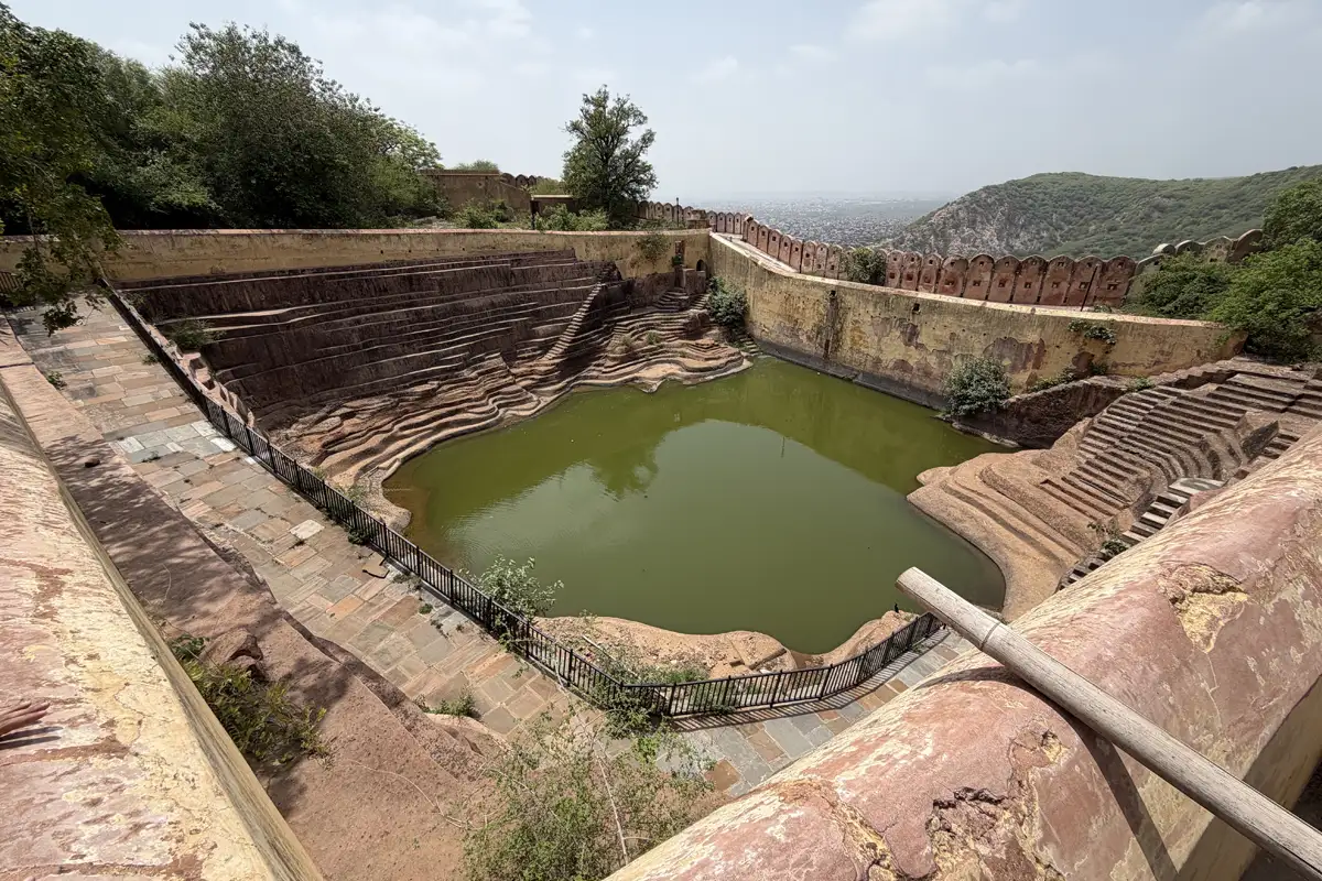 Historical stepwell with stone stairs and green water at Nahargarh Fort in Jaipur taken on 12 July 2026
